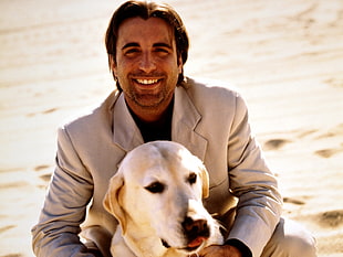 man in suit jacket behind dog