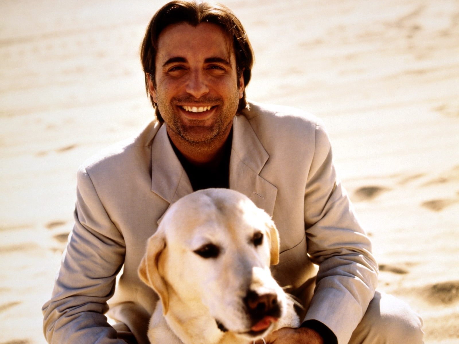 man in suit jacket behind dog