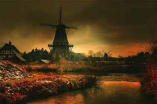 silhouette image of windmill near body of water during golden hour HD wallpaper