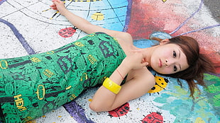 woman in green strapless dress lying down