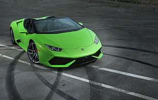 green Lamborghini Huracan on black top road HD wallpaper