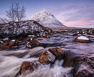 body of water near snow covered mountain
