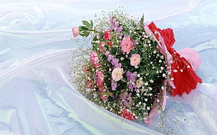 pink flower bouquet on white textile