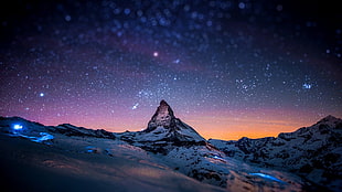 snow-capped mountain under star field
