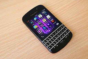 black BlackBerry qwerty phone on brown wooden surface HD wallpaper