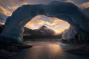 body of water with ice arch formation during golden hour