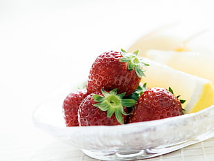 red strawberry fruits and sliced lemons in white bowl photo
