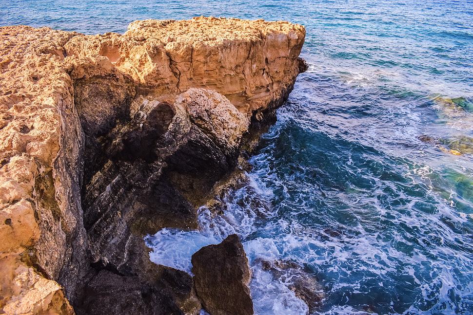 cliff across the ocean under sunny sky HD wallpaper