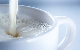 white liquid pouring in white ceramic cup