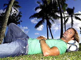 man lying on back with soccer ball pillow closeup photography