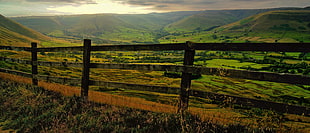 gray wooden fence and green hills