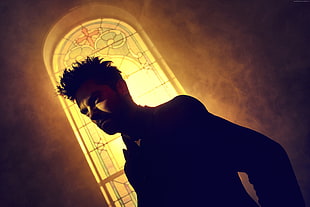 black suited man beside stained glass window
