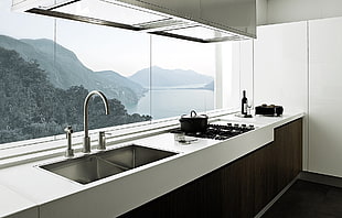 white and black wooden kitchen cabinet set near clear glass window during daytime