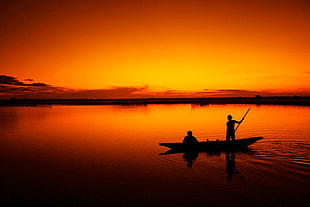 silhouette of men fishing during sunset