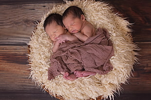 two newborn babies sleeping on white fleece bed covered in gray blanket HD wallpaper