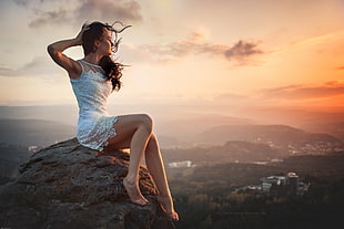 woman sitting on rock holding her head HD wallpaper