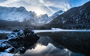 snow mountain under cloudy sky near body of water