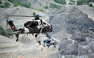two black and gray helicopters on flight