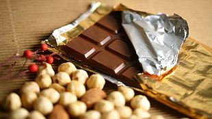 closeup photo of chocolate bar beside brown beans