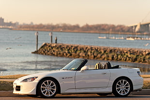 white convertible coupe parking near body of water