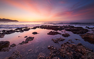 body of water near rock formation during sunset, cala HD wallpaper