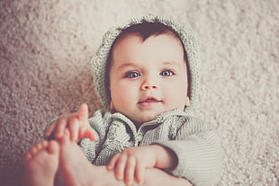 close-up photo of baby wearing gray hoodie clothes