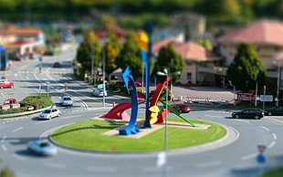 multicolored diorama of round about with cars and house