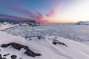 white snowfield mountain with orange sky long exposure photography