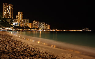 landscape photography of cityscape in seaside during nighttime