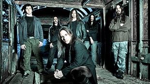 six men wearing jackets standing on gray wooden floor
