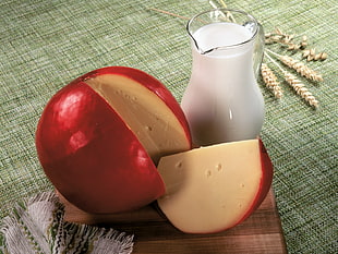 slice of red cheese ball with pitcher of milk