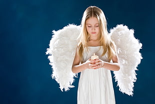 shallow focus photography of a girl wearing angel costume and holding candle