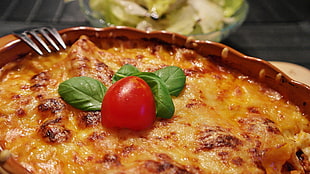 baked food with green leaves and tomato on top