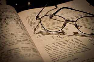 eyeglasses with silver frames, books, glasses