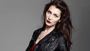 woman in red shirt with black leather jacket and silver-colored necklace