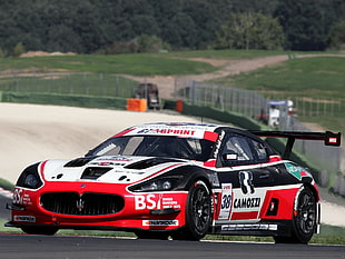 red and black Maserati racing car on asphalt road