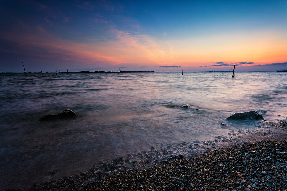 seashore under blue and orange sky during daytime HD wallpaper