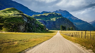 gray rough road beside green field across mountains, landscape, road, mountains, nature