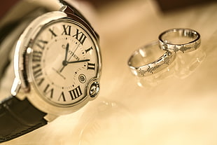 round white Cartier analog watch and silver-colored wedding bands, watches, luxury watches, rings, Cartier