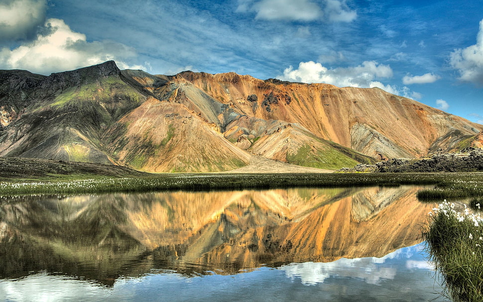 brown mountain near body of water HD wallpaper