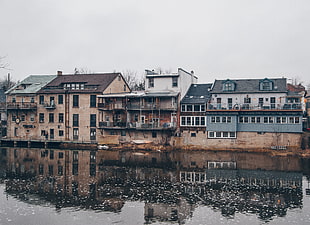 photo of beige and gray concrete building near river during day time
