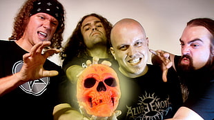 men in black crew-neck shirts holding glowing human skull