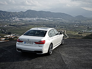 white BMW sedan parked on gray pavement