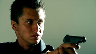 man holding black pistol