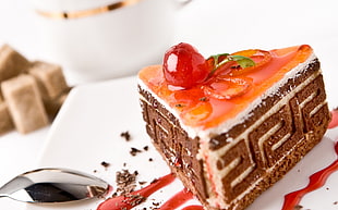 slice of cake beside stainless steel spoon in white surface