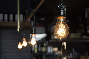 selective focus photography of four light bulbs