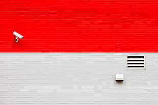 red and white building with white surveillance camera
