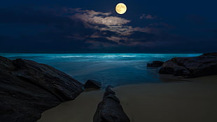 full moon above a blue sea at night