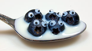 photo of black fruits on spoon