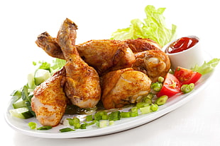 fried chickens with vegetables on oval white ceramic plate